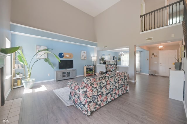 12677 Honors Dr, Carmel, IN 46033 - living area featuring high vaulted ceiling, wood finished floors, baseboards, and a chandelier