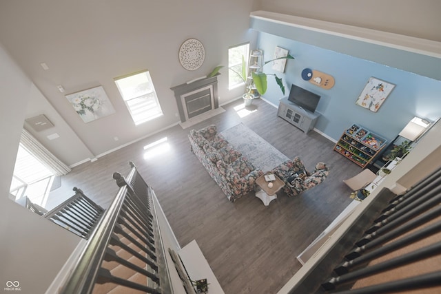 12677 Honors Dr, Carmel, IN 46033 - living area with wood finished floors, a fireplace with flush hearth, baseboards, and a towering ceiling