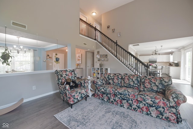 12677 Honors Dr, Carmel, IN 46033 - living area with wood finished floors, baseboards, a chandelier, a towering ceiling, and stairway