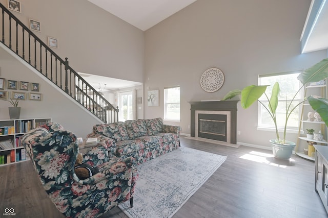 12677 Honors Dr, Carmel, IN 46033 - living room with a towering ceiling, stairs, wood finished floors, baseboards, and a tiled fireplace