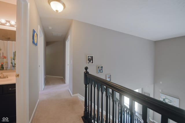 12677 Honors Dr, Carmel, IN 46033 - hall with an upstairs landing, light carpet, baseboards, and a sink