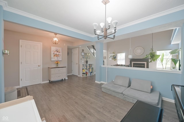 12677 Honors Dr, Carmel, IN 46033 - living room with a chandelier, wood finished floors, crown molding, healthy amount of natural light, and baseboards