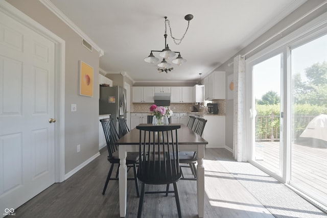 12677 Honors Dr, Carmel, IN 46033 - dining room featuring healthy amount of natural light, a chandelier, ornamental molding, baseboards, and wood finished floors