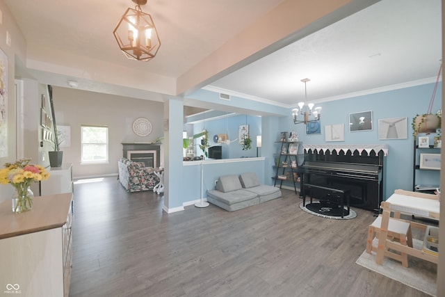 12677 Honors Dr, Carmel, IN 46033 - living room featuring a fireplace, a chandelier, wood finished floors, and crown molding