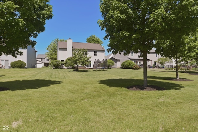 12677 Honors Dr, Carmel, IN 46033 - view of grassy yard with a trampoline