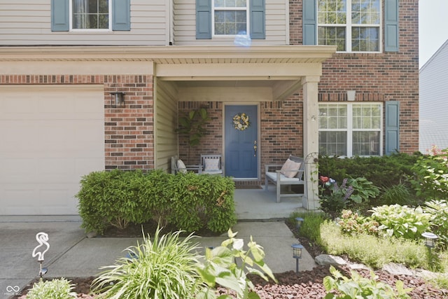 12677 Honors Dr, Carmel, IN 46033 - doorway to property with brick siding, an attached garage, and covered porch