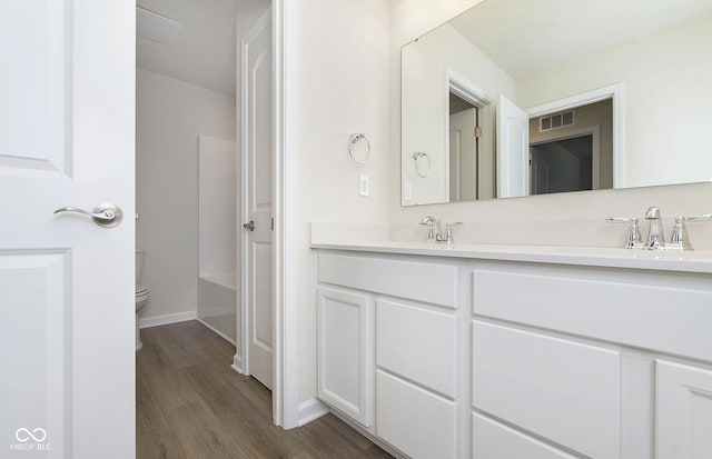 9741 Oleander Dr, Fishers, IN 46250 - bathroom with double vanity, toilet, wood finished floors, and baseboards