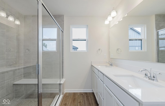 9741 Oleander Dr, Fishers, IN 46250 - full bathroom with double vanity, wood finished floors, and a shower stall