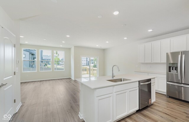 9741 Oleander Dr, Fishers, IN 46250 - kitchen featuring appliances with stainless steel finishes, recessed lighting, a center island with sink, light wood-style floors, and light countertops