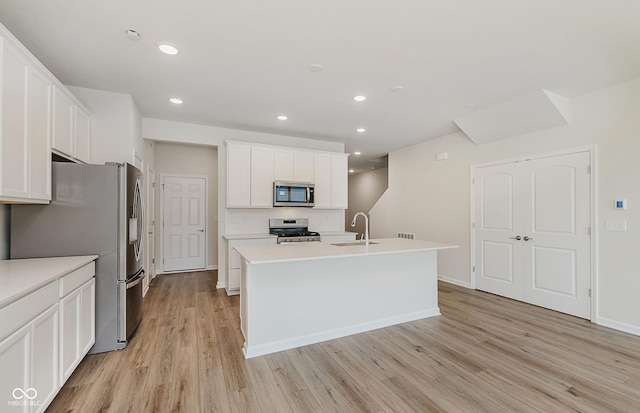 9741 Oleander Dr, Fishers, IN 46250 - kitchen with appliances with stainless steel finishes, light wood-type flooring, white cabinets, recessed lighting, and a center island with sink