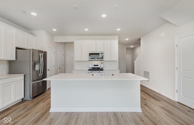 9741 Oleander Dr, Fishers, IN 46250 - kitchen with stainless steel appliances, light wood-type flooring, an island with sink, decorative backsplash, and light countertops