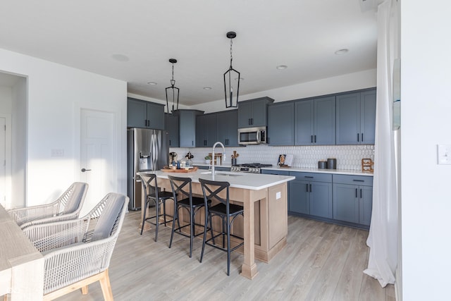 1088 Bevy Blvd, Danville, IN 46122 - kitchen featuring stainless steel appliances, a sink, a kitchen bar, light countertops, and light wood finished floors