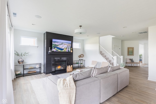1088 Bevy Blvd, Danville, IN 46122 - living room with stairway, light wood-style flooring, and a large fireplace