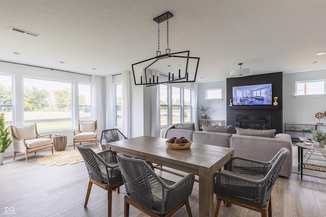 1088 Bevy Blvd, Danville, IN 46122 - dining room featuring a large fireplace, light wood finished floors, and a chandelier