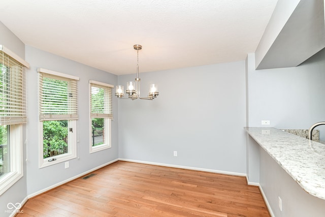 558 E Vermont St, Indianapolis, IN 46202 - unfurnished dining area featuring light wood-style floors, a chandelier, and baseboards