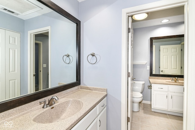 558 E Vermont St, Indianapolis, IN 46202 - bathroom featuring tile patterned flooring, two vanities, toilet, and baseboards