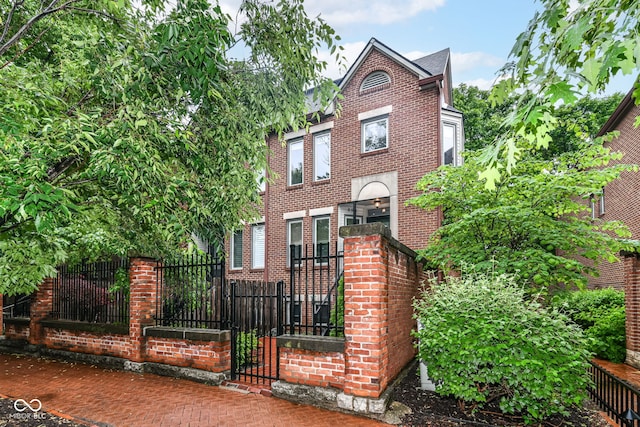 558 E Vermont St, Indianapolis, IN 46202 - view of front facade with brick siding and a fenced front yard