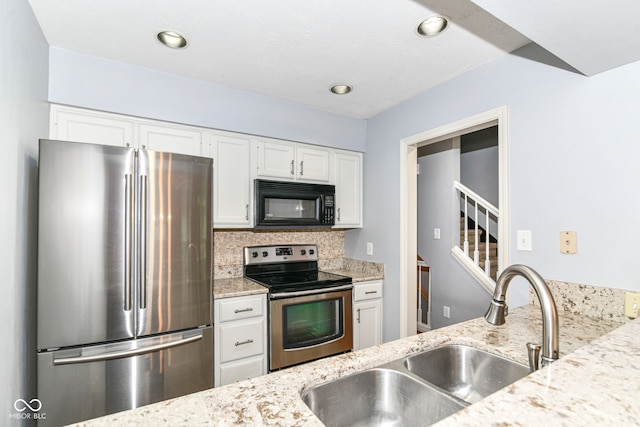 558 E Vermont St, Indianapolis, IN 46202 - kitchen featuring appliances with stainless steel finishes, a sink, white cabinetry, light stone counters, and decorative backsplash