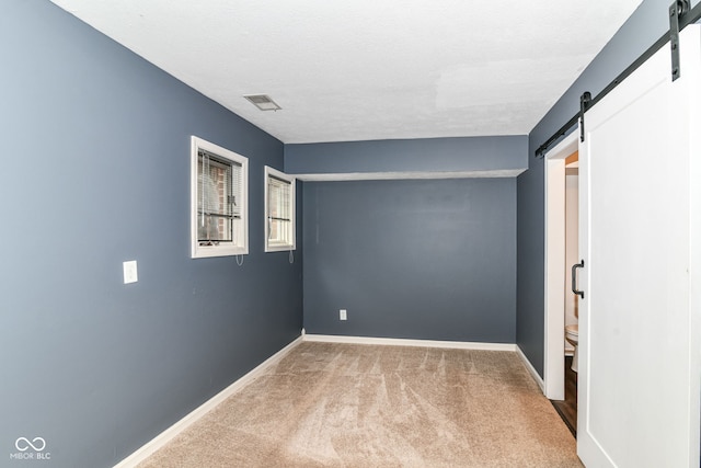 558 E Vermont St, Indianapolis, IN 46202 - carpeted empty room with a barn door and baseboards