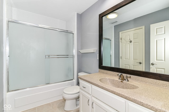 558 E Vermont St, Indianapolis, IN 46202 - full bathroom featuring tile patterned flooring, toilet, vanity, and enclosed tub / shower combo