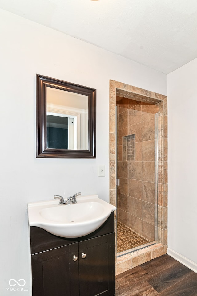 558 E Vermont St, Indianapolis, IN 46202 - bathroom with a stall shower, wood finished floors, vanity, and baseboards