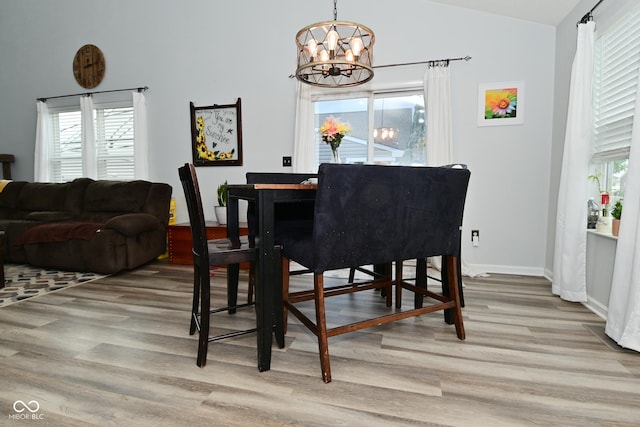 7515 Brattle Dr, Indianapolis, IN 46113 - dining space with light wood-type flooring, a chandelier, vaulted ceiling, and baseboards