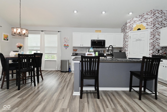 7515 Brattle Dr, Indianapolis, IN 46113 - kitchen featuring dark countertops, a chandelier, light wood finished floors, backsplash, and recessed lighting