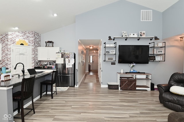 7515 Brattle Dr, Indianapolis, IN 46113 - living room with high vaulted ceiling, light wood finished floors, baseboards, and recessed lighting
