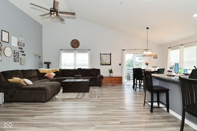 7515 Brattle Dr, Indianapolis, IN 46113 - living room with high vaulted ceiling, light wood finished floors, a chandelier, and a ceiling fan
