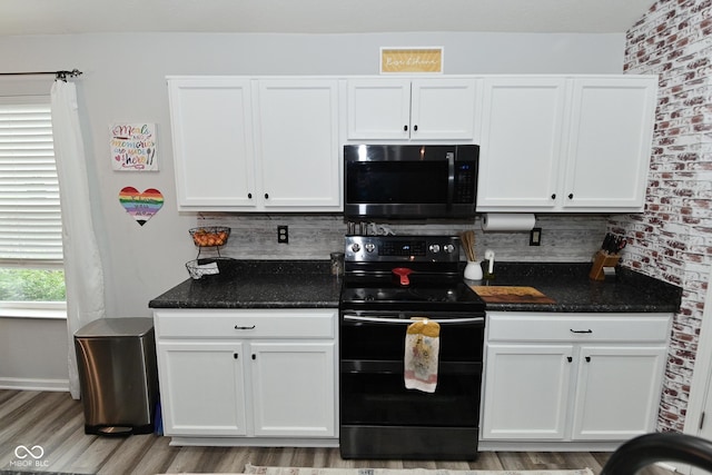 7515 Brattle Dr, Indianapolis, IN 46113 - kitchen featuring black electric range, white cabinetry, light wood finished floors, and backsplash