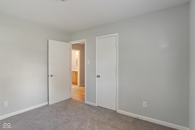 1002 Collier St, Indianapolis, IN 46241 - unfurnished bedroom with light colored carpet and baseboards