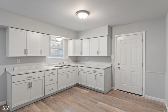 1002 Collier St, Indianapolis, IN 46241 - kitchen with a sink, light wood-type flooring, light countertops, and white cabinetry