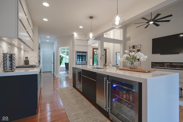 11911 W Grandview Dr, Columbus, IN 47201 - kitchen featuring beverage cooler, a sink, open floor plan, light countertops, and dark cabinets