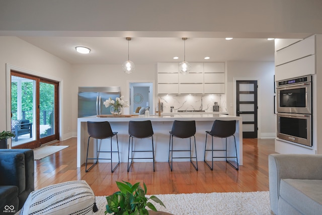11911 W Grandview Dr, Columbus, IN 47201 - kitchen featuring appliances with stainless steel finishes, modern cabinets, open floor plan, light wood finished floors, and recessed lighting