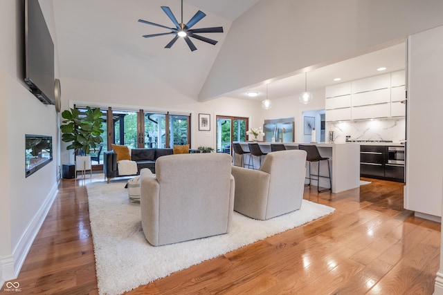 11911 W Grandview Dr, Columbus, IN 47201 - living room with light wood finished floors, high vaulted ceiling, a ceiling fan, recessed lighting, and baseboards