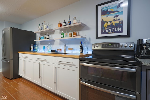 11911 W Grandview Dr, Columbus, IN 47201 - kitchen with stainless steel appliances, white cabinets, wood counters, and dark tile patterned flooring