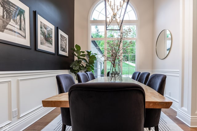 11911 W Grandview Dr, Columbus, IN 47201 - dining area featuring a chandelier, a decorative wall, wainscoting, and dark wood-style floors