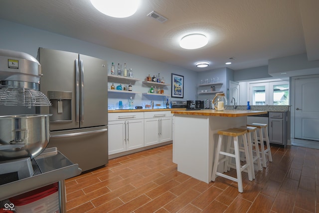11911 W Grandview Dr, Columbus, IN 47201 - kitchen with stainless steel fridge with ice dispenser, butcher block countertops, open shelves, and wood finished floors
