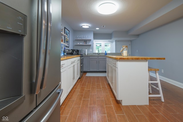 11911 W Grandview Dr, Columbus, IN 47201 - kitchen featuring freestanding refrigerator, butcher block counters, a kitchen bar, open shelves, and a sink