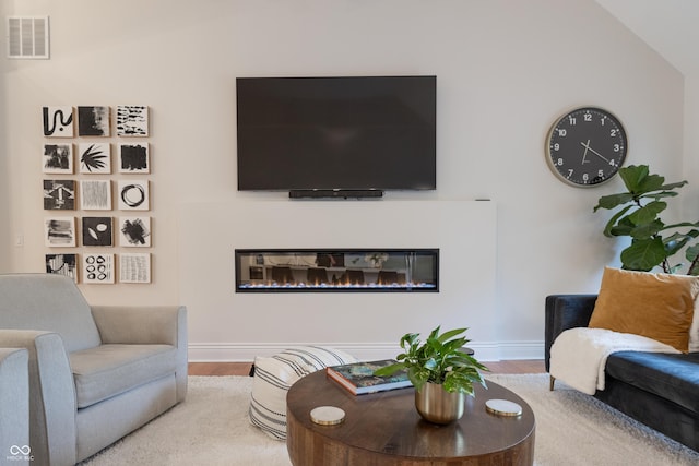 11911 W Grandview Dr, Columbus, IN 47201 - living room featuring wood finished floors, a glass covered fireplace, and baseboards