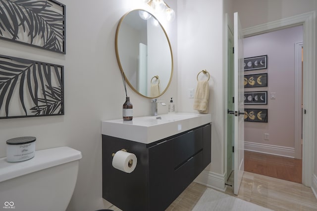 11911 W Grandview Dr, Columbus, IN 47201 - bathroom with toilet, vanity, baseboards, and wood finished floors