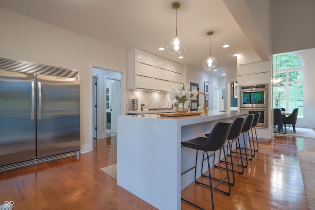 11911 W Grandview Dr, Columbus, IN 47201 - kitchen featuring stainless steel appliances, modern cabinets, white cabinets, hardwood / wood-style flooring, and pendant lighting