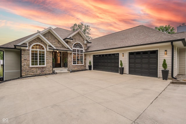 11911 W Grandview Dr, Columbus, IN 47201 - view of front facade with a garage, driveway, roof with shingles, and stone siding