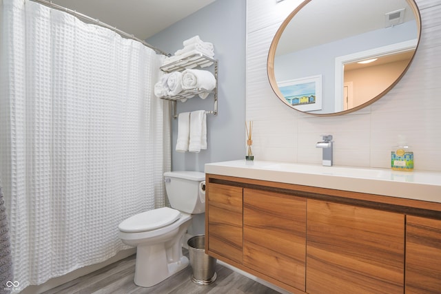 11911 W Grandview Dr, Columbus, IN 47201 - bathroom with decorative backsplash, toilet, wood finished floors, and vanity