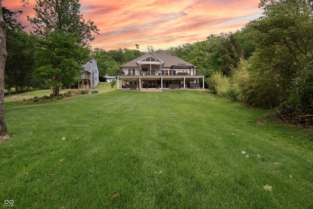 11911 W Grandview Dr, Columbus, IN 47201 - back of house at dusk featuring a lawn and a deck