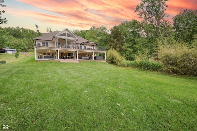 11911 W Grandview Dr, Columbus, IN 47201 - back of house at dusk featuring a patio, a wooden deck, a lawn, and ceiling fan
