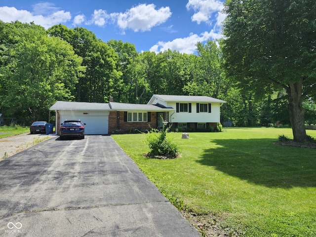 10307 Orchard Park Dr S, Carmel, IN 46280 - split level home featuring a garage, asphalt driveway, a front lawn, and brick siding