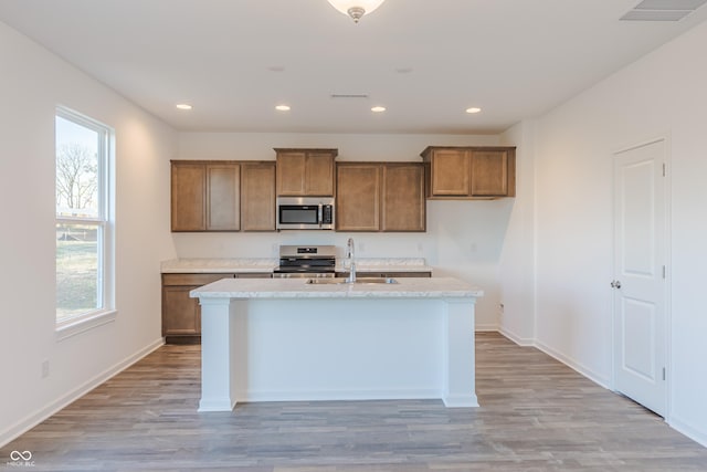 1108 Bevy Blvd, Danville, IN 46122 - kitchen featuring stainless steel appliances, a sink, brown cabinets, a center island with sink, and recessed lighting