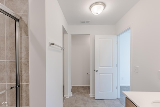 1108 Bevy Blvd, Danville, IN 46122 - bathroom featuring vanity, a tile shower, tile patterned floors, and baseboards