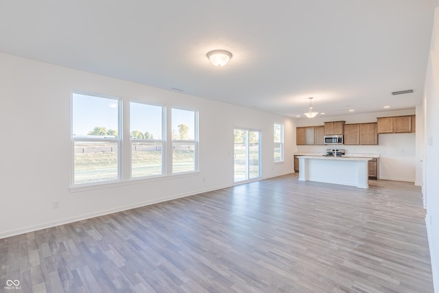 1108 Bevy Blvd, Danville, IN 46122 - unfurnished living room with light wood-type flooring, baseboards, and recessed lighting